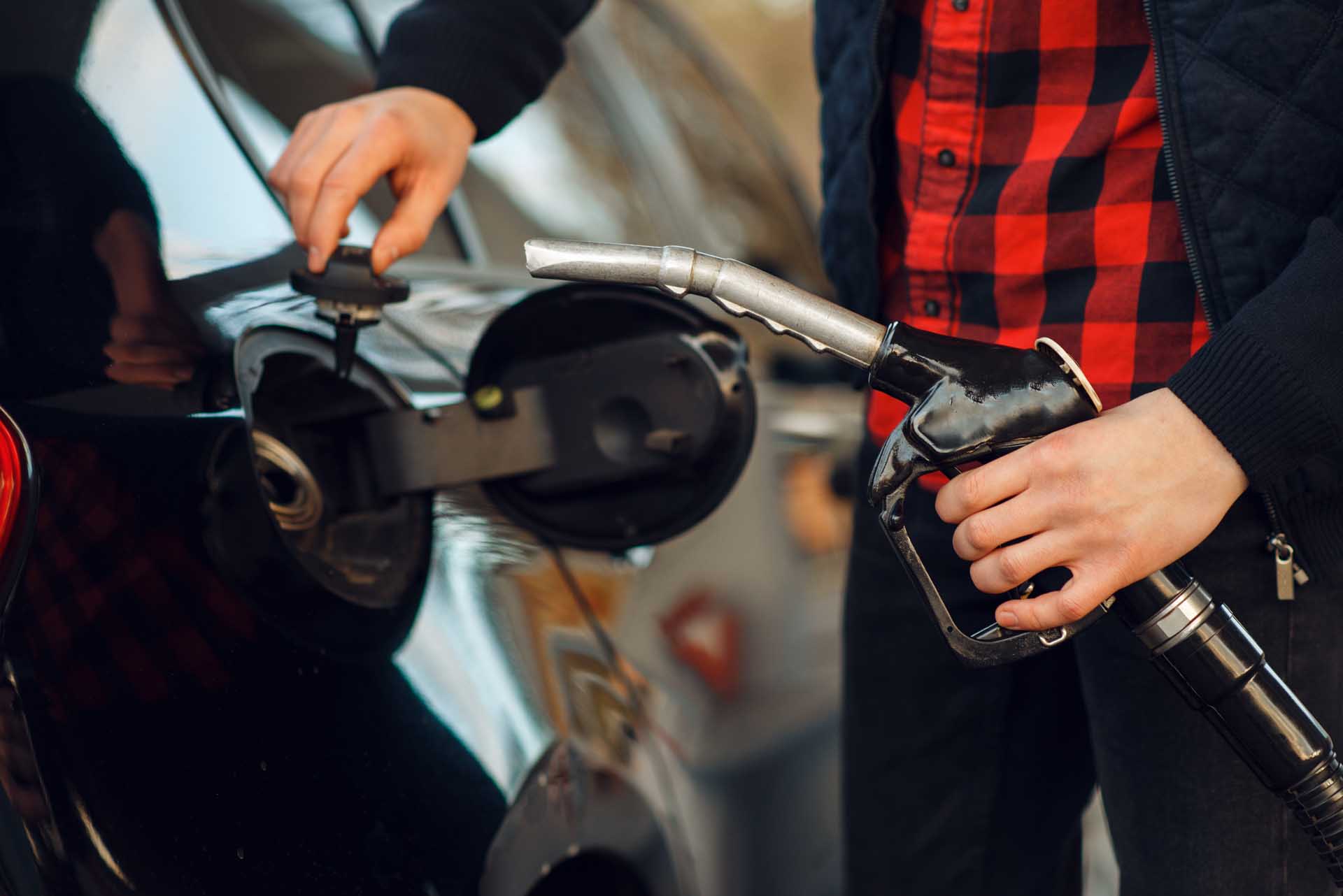 Man inserts the in into the tank on a gas station